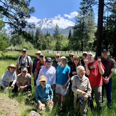 nature walk attendees pose in front of Mt Shasta at Luginbuhl Ranch Preserve.